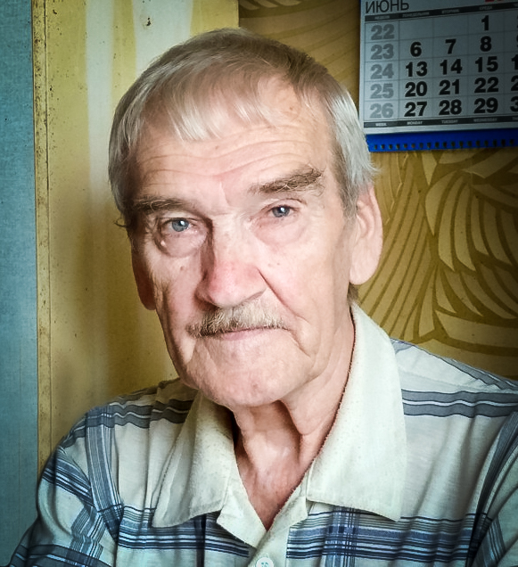 Portrait of Stanislav Petrov in 2016, an older man with gray hair and a mustache in a plaid shirt